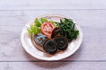 preserved egg are made from duck eggs soaked in the lye of black tea, lime, salt, wood ash, until the meat inside is clear black.
