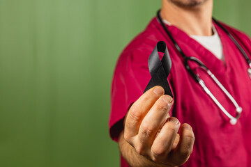 Healthcare worker holding black ribbon in awareness initiative setting