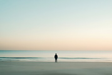 Fototapeta premium Solitary Figure Beach Seascape Peaceful Sunrise Ocean View man sky calm sand water shore coast alone