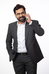 Fototapeta premium Indian happy business corporate man taking on mobile phone on white background. Concept of digital and business technology