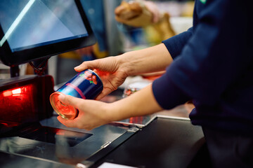 Close up of cashier scanning goods at store.
