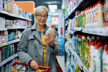 Happy senior woman buying at supermarket.