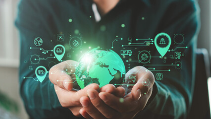 Businessman hand holding virtual green globe with green logistics icon representing eco-friendly transportation. Green logistic or Sustainable transport. sustainable logistics.