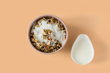 Granola with yogurt . Side view of a ceramic bowl with granola  and yoghurt on the beige background . Muesli with dried fruit close-up . 