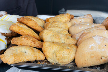 Freshly baked pies on a large tray with crispy crust