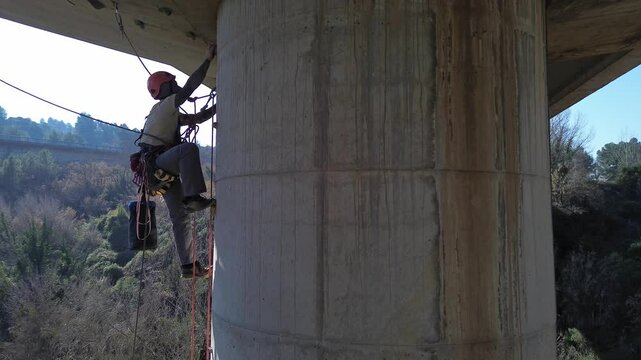 Technician performing inspection on bridge pylon