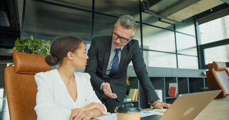 Two professionals reviewing documents in office