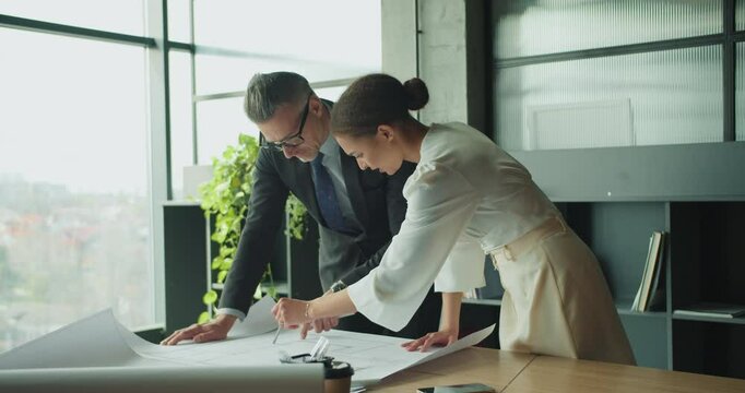 Architects discussing floor plan in modern office