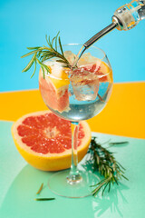 Refreshing summer cocktail with gin, tonic, grapefruit, and rosemary.
