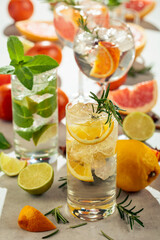 Refreshing summer cocktails with citrus on a white marble table.