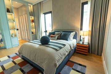 Fototapeta premium Modern cobalt blue bedroom with double bed with carpet and window.