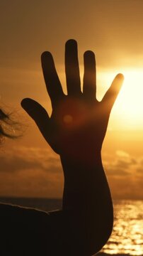 Vertical shot. Happy little boy dreamer, child catching sun rays with fingers, sunset at ocean, happy childhood concept, 4-5 caucasian boy, positive thinking, human hand, child dream, tranquil scene