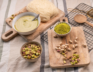 Zutaten für trendige Dubai-Schokolade mit Pistazie – Flatlay mit Fadenteig, Pistazien und Pistaziencreme