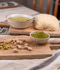 Zutaten f&uuml;r trendige Dubai-Schokolade mit Pistazie &ndash; Flatlay mit Fadenteig, Pistazien und Pistaziencreme
