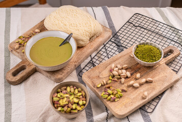 Zutaten für trendige Dubai-Schokolade mit Pistazie – Flatlay mit Fadenteig, Pistazien und Pistaziencreme