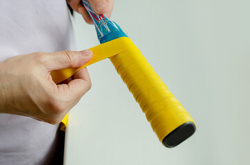 Wrapping Yellow Grip Tape on a Squash Racket Handle