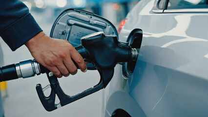 Filling up the Tank: A close-up shot of a hand filling a car's fuel tank with gasoline, highlighting the modern-day ritual of refueling. The image captures a simple yet essential act in everyday life.