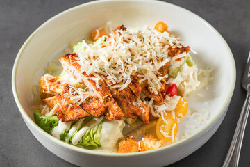 Top view of chicken caesar salad on grey stone table
