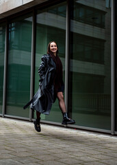 Woman running and jumping in front of an office building in Stuttgart, Germany