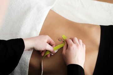 Spa, Abdominal Taping, Applying Tape To Young Woman's Abdomen, Top View, No Face. High quality photo