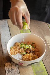 Thai dish flavor enhancement lime squeeze in rustic kitchen photography