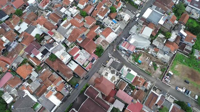 A three-way intersection, with motorcycles and cars passing by, captured by a stationary drone.








