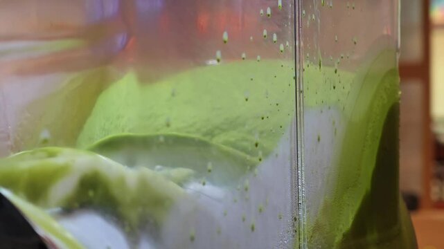 A shot of a matcha slurpee machine mixing.