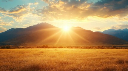 Stunning sunrise over open field with mist rolling in and beautiful layers of light highlighting the mountains
