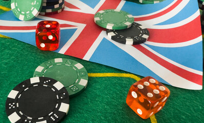 Dice with poker chips and playing card on background of dollar bills. flag of Great Britain