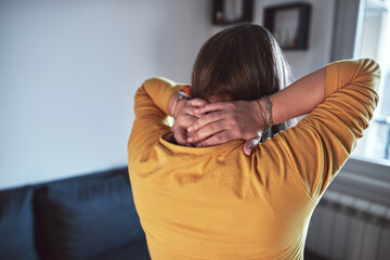Woman with neck pain at home.