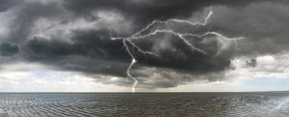 Ein Orkantief mit grauen Gewitterwolken zieht über die Küstenlandschaft der Nordseeinsel Föhr