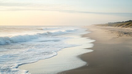 Soft golden light washes a tranquil beach shoreline.