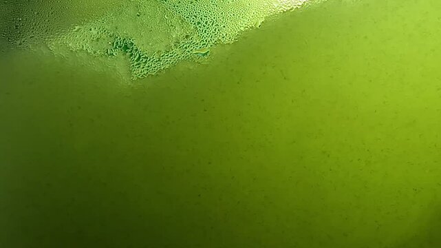 Drops of condensation on the green ice cream tank. Ice cold sorbet machine mixing fruit juice. Freezing slush spinning around, summer treat.