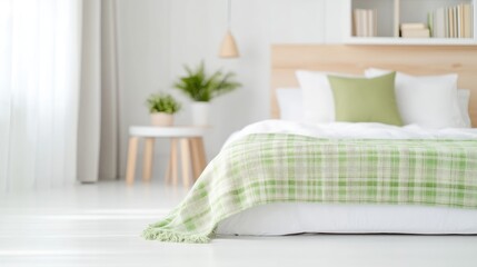 Modern bedroom with soft green accents.  A cozy, bright space with a light-colored bed, pale green throw, and wooden accents