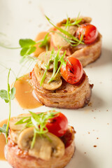 Savory dish featuring mushrooms and cherry tomatoes served on a white plate at a dining establishment