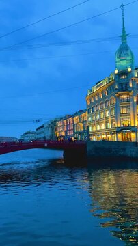 Russia, April 9, 2024: Boats on the canal in St. Petersburg in spring. Bridges and historical buildings on the river embankment, people walking along the embankment. Reflections of houses in the water