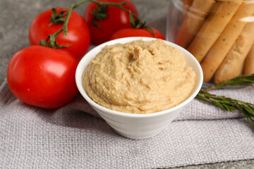 Bowl with tasty hummus on table, closeup
