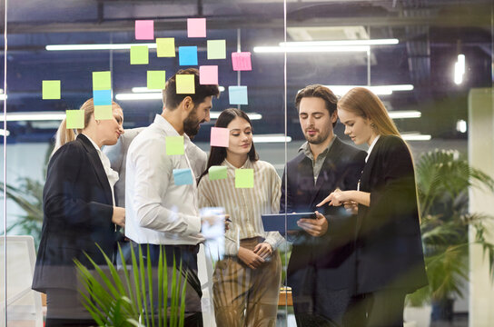 Focused business people team engaged in conversation and negotiation during a meeting in the modern office. Working together and discussing work strategies to foster successful outcomes.