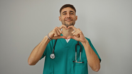 Young man in medical scrubs making heart shape with hands isolated on white background, showcasing...