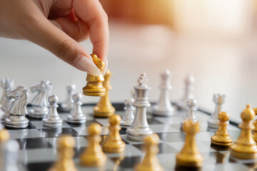 Side view close-up of woman hand move chess piece in strategic board game.