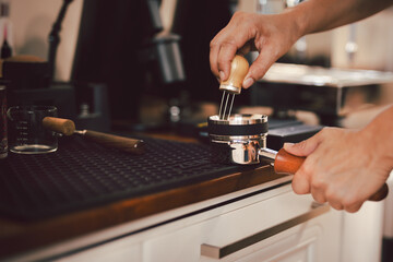 Barista leveling ground coffee in the portafilter..