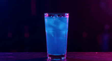 Tall glass filled with vibrant blue liquid and ice cubes against dramatic pink and blue neon background lighting. Refreshing modern beverage presentation.