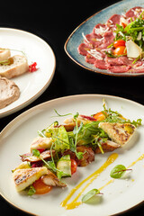 Gourmet dishes featuring grilled vegetables and meats served on elegant plates during a fine dining experience