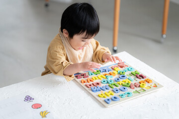 アルファベットパズルをする1歳の男の子