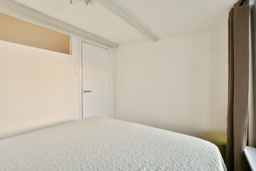 A pristine modern bedroom showcasing a clean design with minimalist decor and ample natural light filtering through the window.