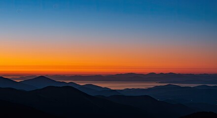Fototapeta premium Serene Sunrise Over Majestic Mountains and Calm Waters