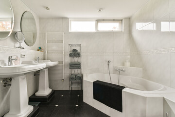 A stylish and spacious bathroom featuring modern fixtures, a luxurious bathtub, and elegant design elements that create a serene atmosphere.