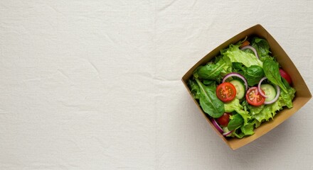 Salad with fresh vegetables in cardboard box on table, delicious ready meal with spinach, tomato and cucumber for healthy diet, fast delivery concept.