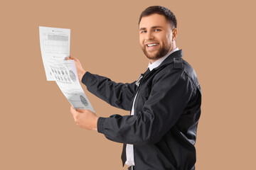 Male police officer with documents on beige background