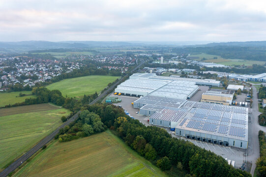 German factory and warehouse outside a village, drone aerial view